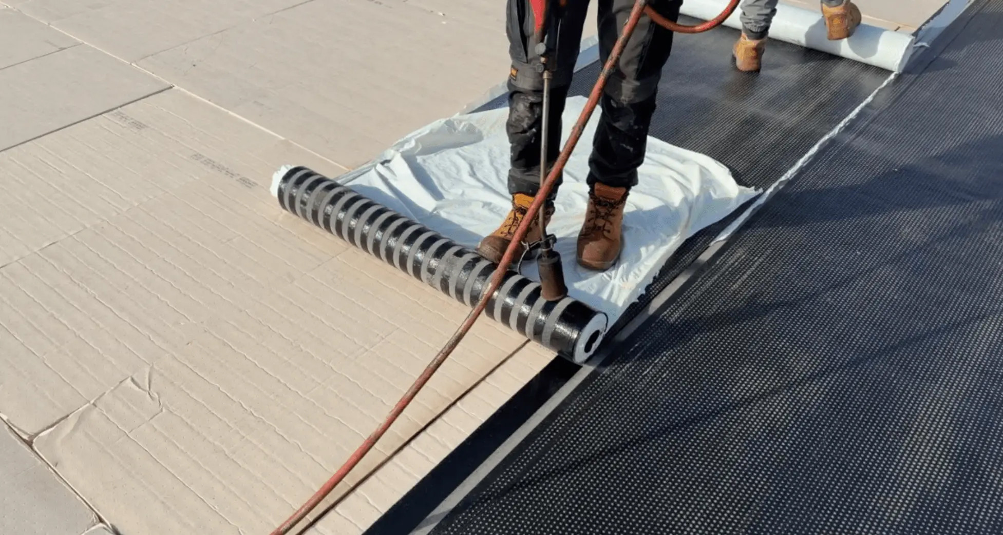 Worker applying a roof insulation sheet