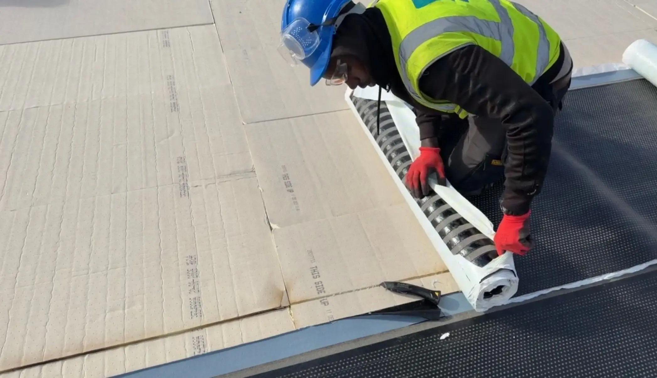 Worker applying a roof insulation sheet